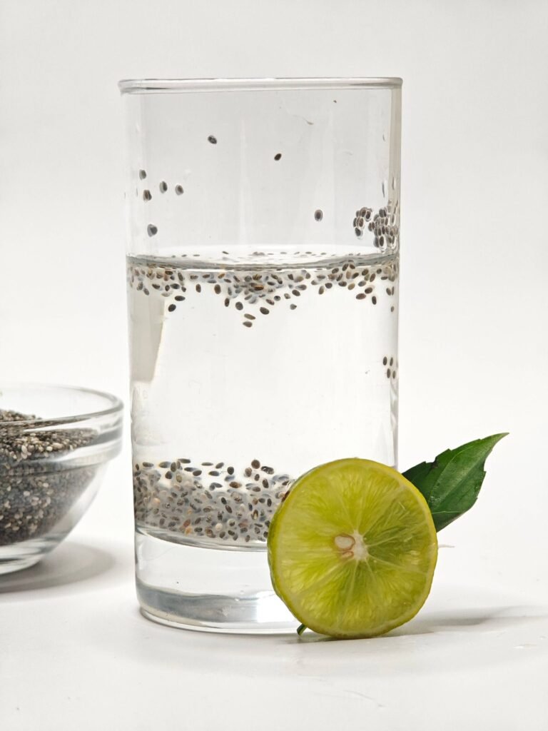 Chia seed water with soaked seeds and lemon beside a measuring spoon